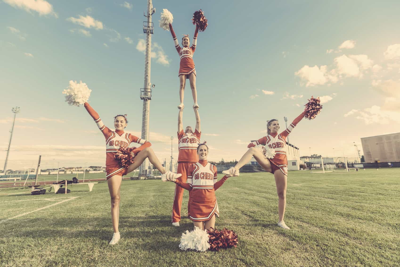 Cheerleaders with red clothing and the sky as background, image for page called more happiness that includes information about life crises, recovery support, psychology podcast, addiction, emotions, well-being, happiness and wellness